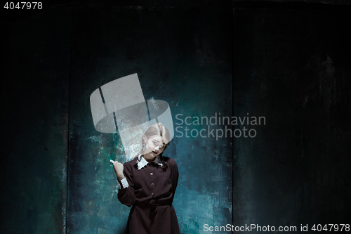 Image of Portrait of a young smiling girl in school uniform as killer woman