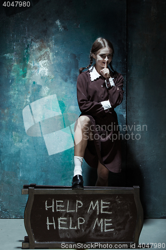 Image of Portrait of a young smiling girl in school uniform as killer woman