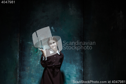 Image of Portrait of a young smiling girl in school uniform as killer woman