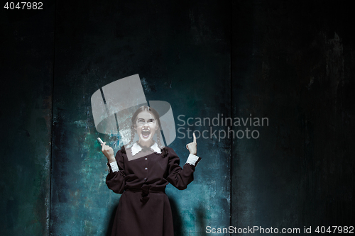 Image of Portrait of a young smiling girl in school uniform as killer woman