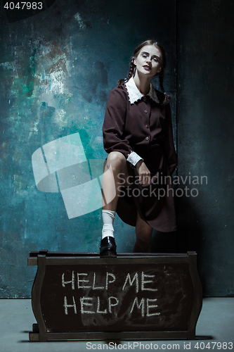 Image of Portrait of a young smiling girl in school uniform as killer woman