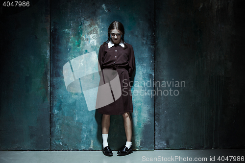 Image of Portrait of a young smiling girl in school uniform as killer woman