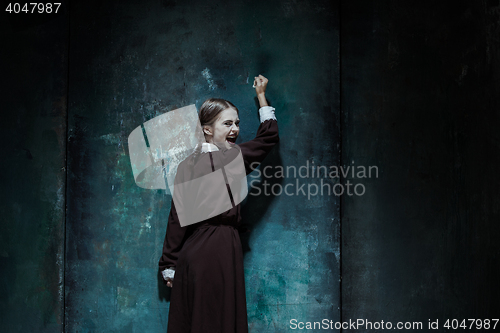 Image of Portrait of a young smiling girl in school uniform as killer woman