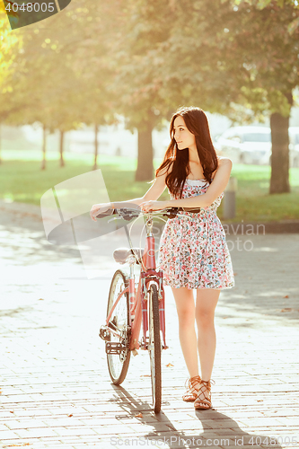 Image of The young girl with bicycle in park