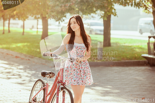 Image of The young girl with bicycle in park