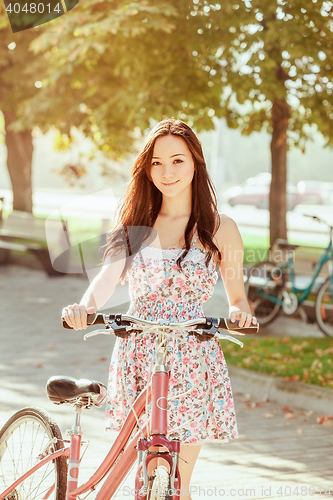 Image of The young girl with bicycle in park