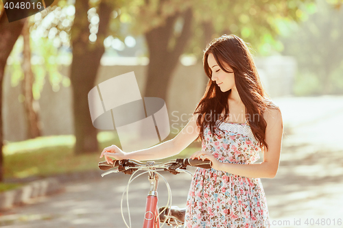 Image of The young girl with bicycle in park
