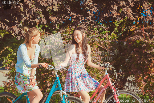 Image of The two young girls with bicycles in park