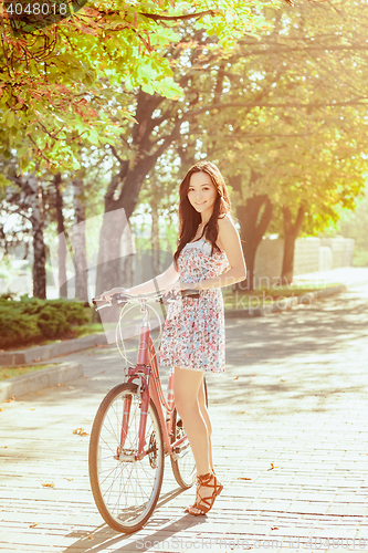 Image of The young girl with bicycle in park