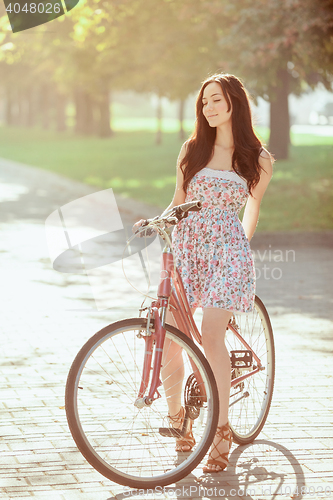 Image of The young girl with bicycle in park