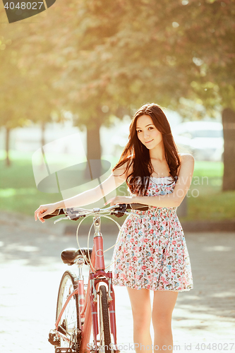Image of The young girl with bicycle in park