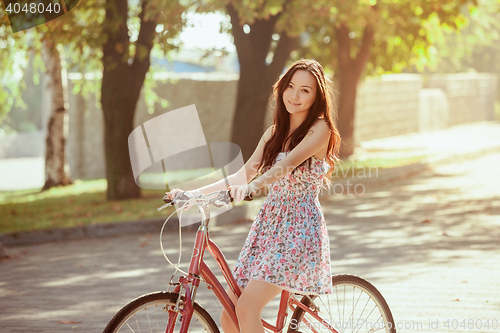 Image of The young girl with bicycle in park