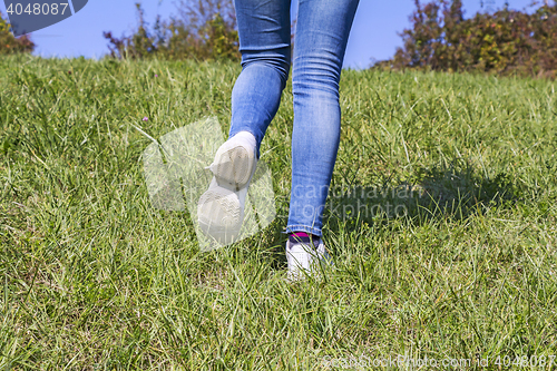 Image of Young girl hiking in nature at green grass