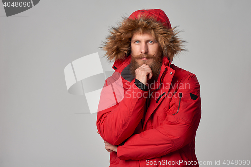 Image of Pensive bearded man in red winter jacket