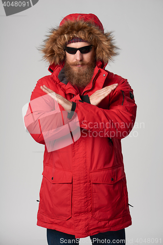 Image of Man wearing red winter jacket gesturing stop enough hand sign