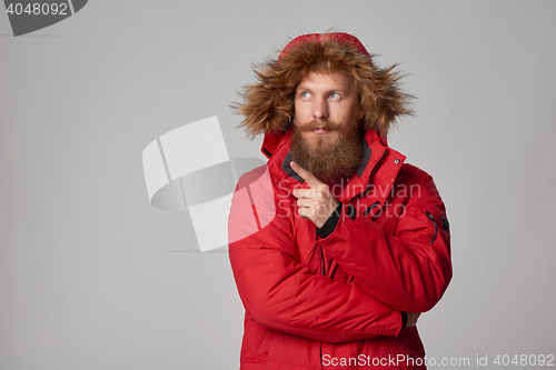 Image of Pensive bearded man in red winter jacket