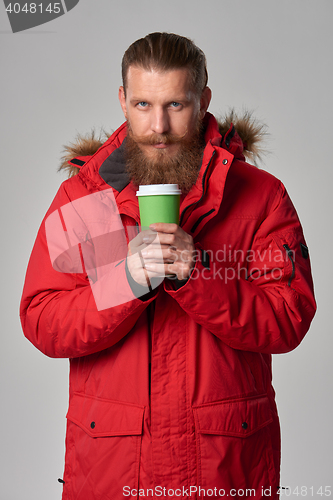 Image of Man in red winter jacket with cup of hot drink