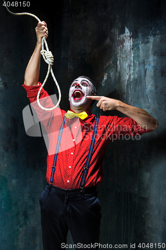 Image of The scary clown and rope for hanging on dack background. Halloween concept