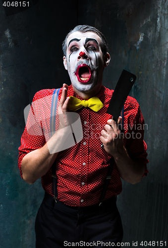 Image of The scary clown holding a knife on dack. Halloween concept