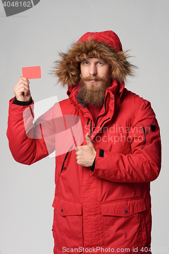 Image of Man wearing red winter Alaska jacket with fur hood on