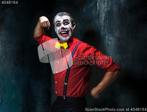 Image of Terrible clown and Halloween theme: Crazy red clown in a shirt with suspenders