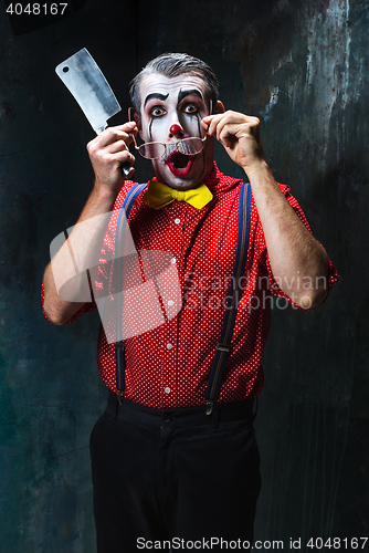 Image of The scary clown holding a knife on dack. Halloween concept