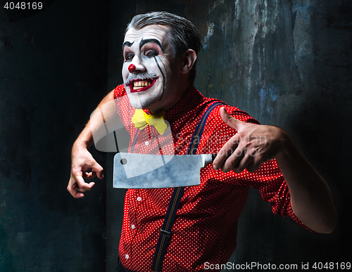 Image of The crazy clown holding a knife on dack. Halloween concept