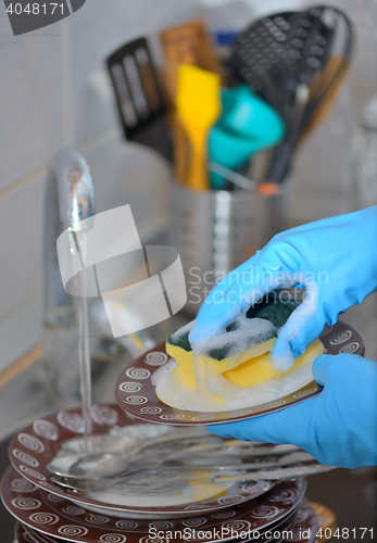 Image of Woman hand washing dishes