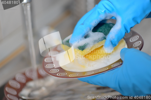 Image of Woman hands washing dishes