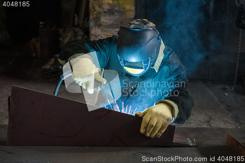 Image of worker welding metal