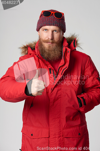 Image of Serious bearded man showing thumb up