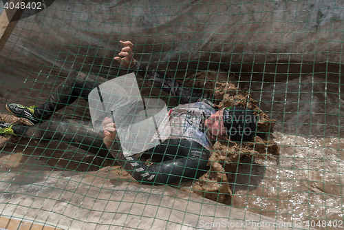 Image of Man creeps on an entrenchment with sand and water