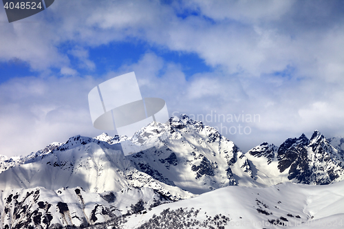 Image of Snow slope and winter sunlight mountains in clouds