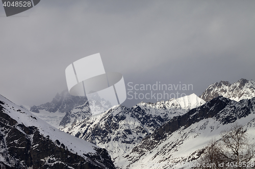 Image of Snow sunlight mountain in fog at gray day before rain