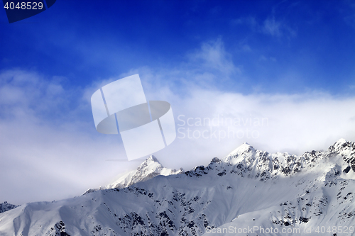 Image of Snow sunlight mountain peak in fog and blue sky