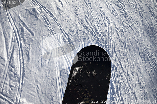 Image of Snowboard over off-piste slope with track from ski and snowboard