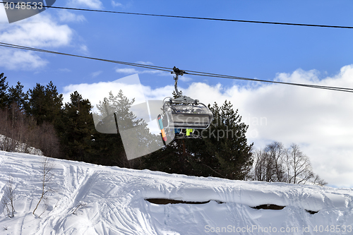 Image of Skiers and snowboarders on chair-lift in winter mountain