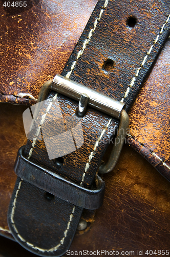 Image of old worn leather bag buckle detail