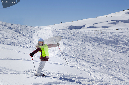 Image of Little skier on ski slope with new fallen snow at sun day