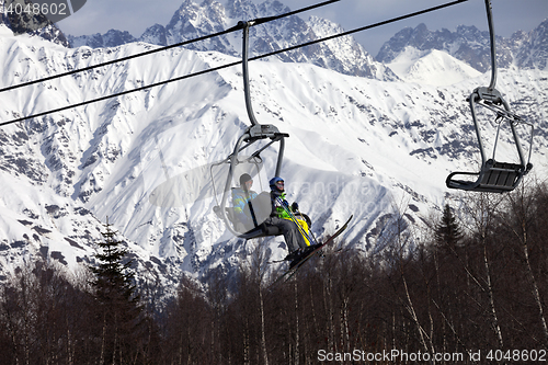 Image of Father and daughter on ski-lift at nice sunny day