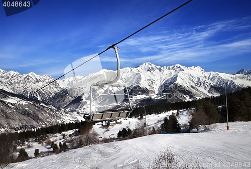 Image of Ski slope and chair-lift in snow winter mountains at sun windy d