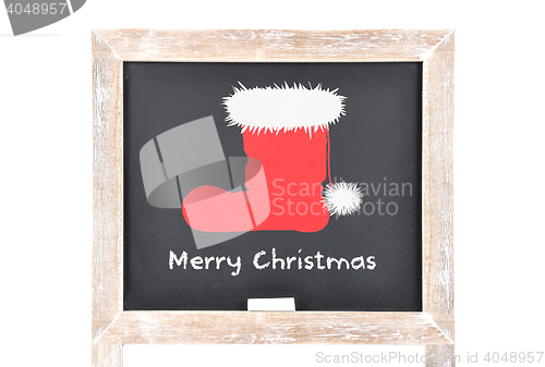 Image of Christmas greetings with Santas hat on blackboard