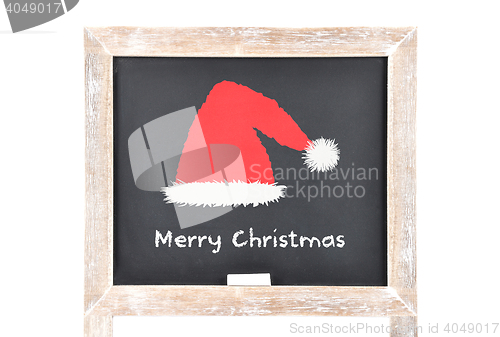 Image of Christmas greetings with Santas hat on blackboard