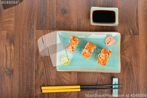Image of Sushi rolls on the wooden table. Overhead view