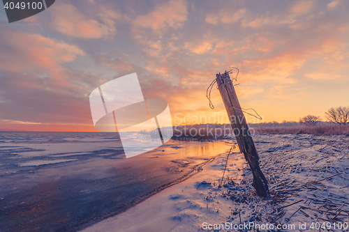 Image of Fence post by a frozen lake