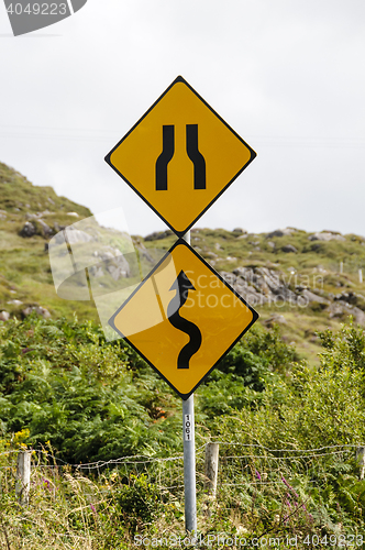 Image of Winding road and bottleneck signs