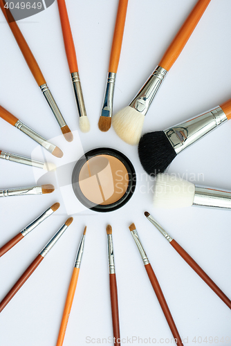 Image of makeup brush and cosmetics, on a white background