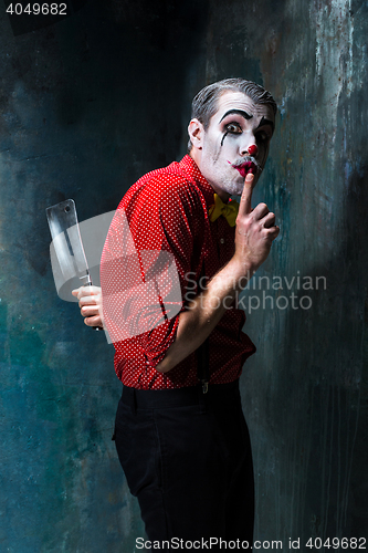 Image of The crazy clown holding a knife on dack. Halloween concept