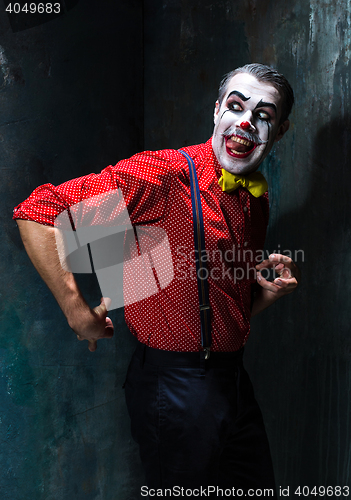 Image of Terrible clown and Halloween theme: Crazy red clown in a shirt with suspenders