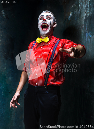 Image of Terrible clown and Halloween theme: Crazy red clown in a shirt with suspenders